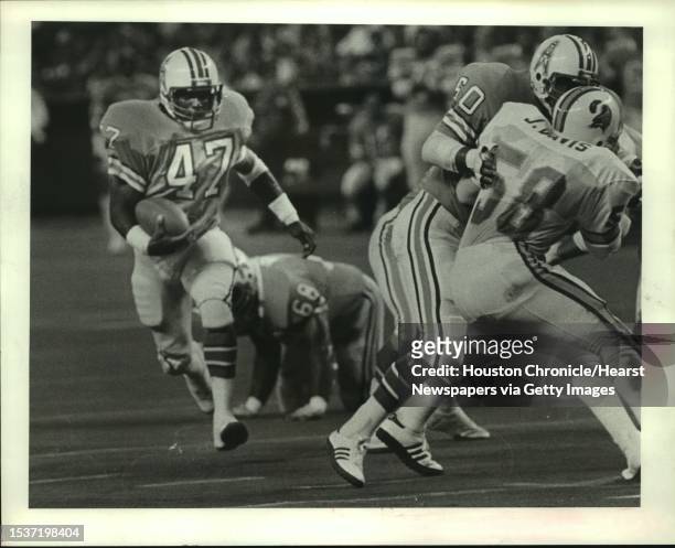 Houston Oilers Ronnie Coleman speeds for a 6-yard gain in the first quarter behind the block of Oilers Ed Fisher on Tampa Bay Bucaneers Jeff Davis .