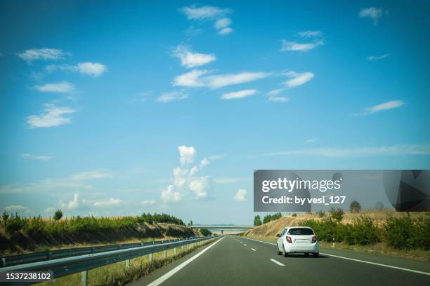 a single car on a highway on a sunny summer day - driving car blue stock pictures, royalty-free photos & images