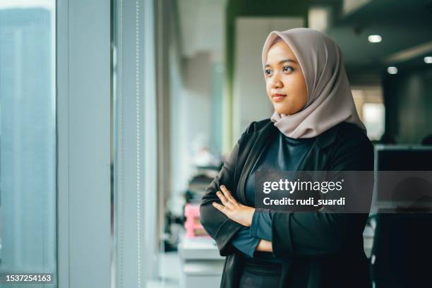 asian businesswoman looking through window - worry business stock pictures, royalty-free photos & images