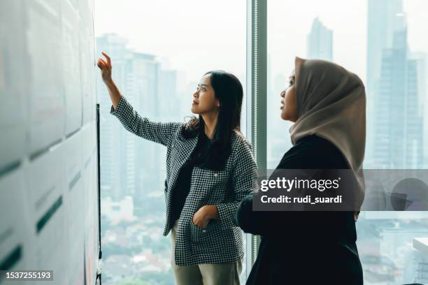 personas asiáticas trabajando y discutiendo en la pizarra en la oficina - woman whiteboard fotografías e imágenes de stock