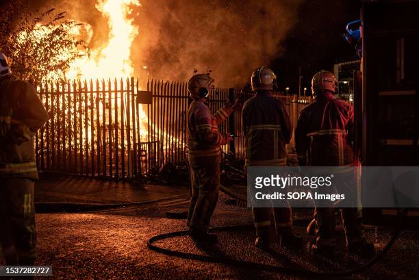 On the eleventh night, firefighters seen in front of a small bonfire near Sandy Row. To celebrate the Battle of the Boyne, bonfires are built in...