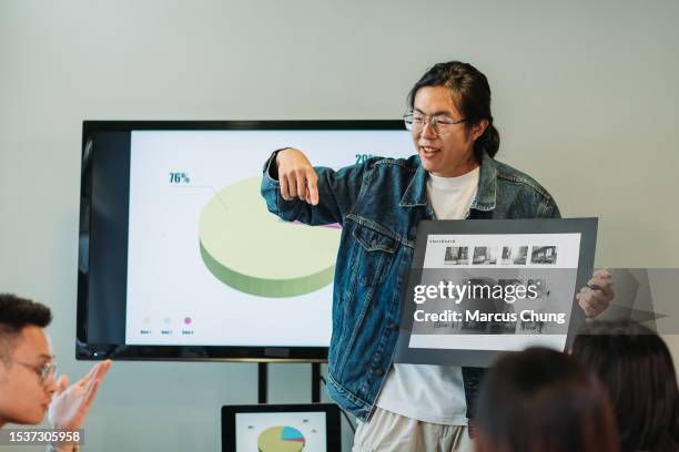 asian chinese handsome young adult giving presentation in front with team at meeting room - storyboard stock pictures, royalty-free photos & images