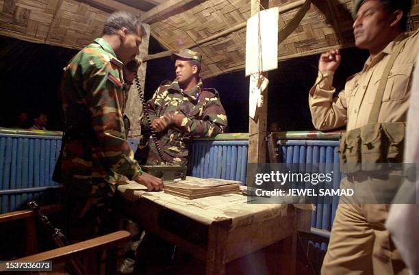 Army soldiers and local policemen keep guard on the main road of Bangladesh's southern district of Rangamati, 19 February 2001, following the...