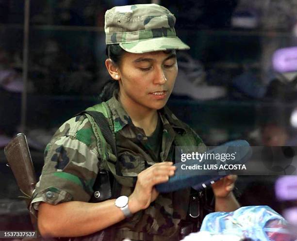 An unidentified woman soldier of the Revolutionary Armed Forces of Colombia buys shoes in San Vicente del Caguan, Caqueta, Colombia, 04 February...