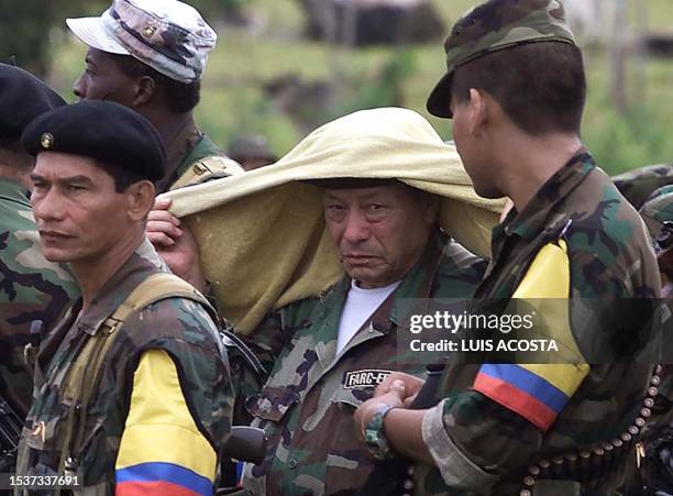 Manuel Marulanda Velez commander in chief of the Revolutionary Armed Forces of Colombia covers his head with a towel while he waits for President...