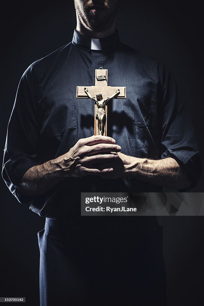 Católica sacerdote segurando um Crucifixo de madeira