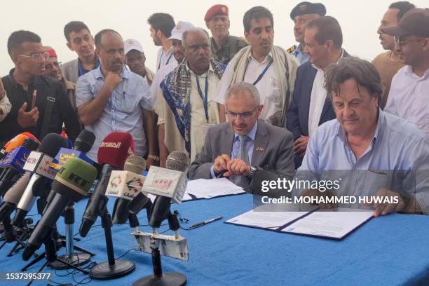 Resident coordinator for Yemen David Gressly and Edrees al-Shami , the Huthi-appointed executive general manager of SEPOC, sign documents on board...