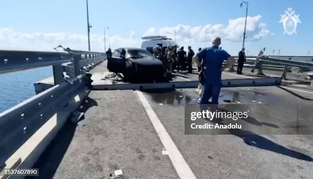 Screen grab captured from a video shows investigation committee members inspecting the scene after an explosion at the Crimea Bridge in Crimea on...