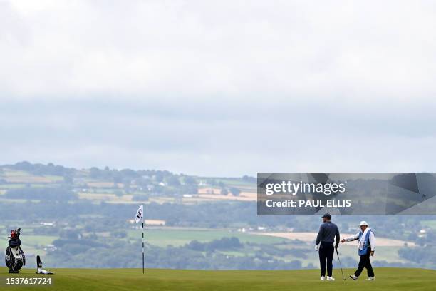 Golfer Bryson DeChambeau talks with his caddie on the 17th green during a practice round for 151st British Open Golf Championship at Royal Liverpool...