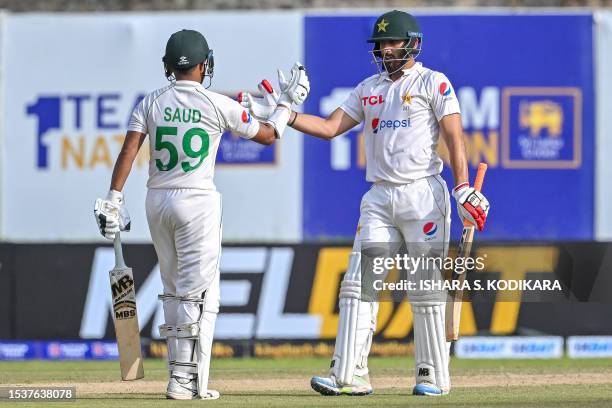 Pakistan's Agha Salman celebrates with Saud Shakeel after scoring a half-century during the second day of the first cricket Test match between Sri...