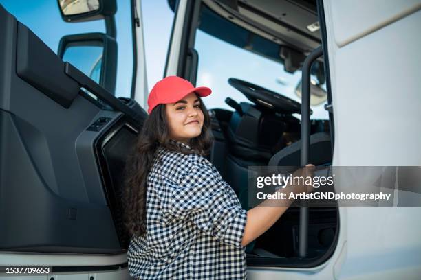 smiling female truck driver getting in the truck. - truck driver stock pictures, royalty-free photos & images