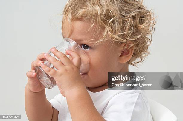 small brown eyed boy with blonde hair drinking from glass - infant with water 個照片及圖片檔