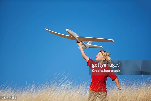 young boy holding toy glider airplane - gliding stock pictures, royalty-free photos & images