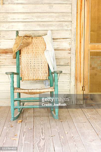 antique green rocking chair on rustic farm porch - rocking chair stockfoto's en -beelden