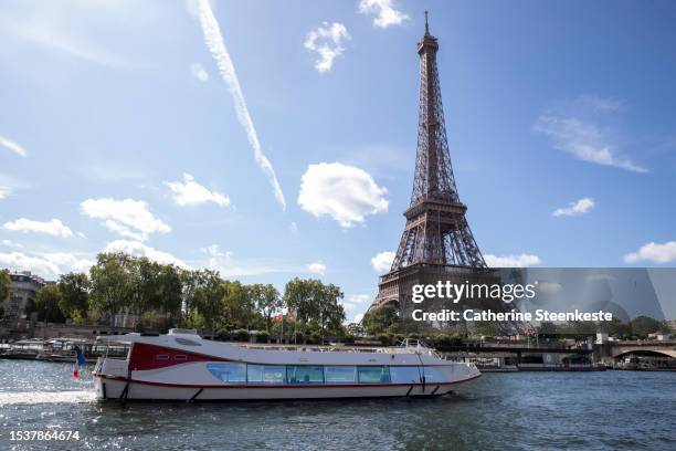 An empty boat travels the river Seine during the technical test event for the Paris 2024 opening ceremony with the Eiffel Tower in the background on...