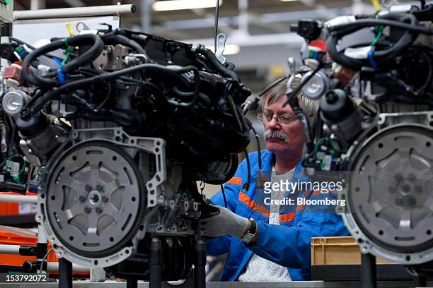An employee assembles an automobile engine on the production line at the Francaise de Mecanique engine plant in Dauvrin, France, on Monday, Oct. 8,...