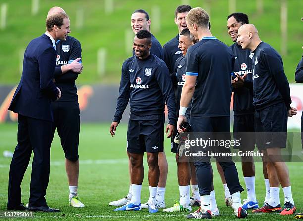 Prince William, Duke of Cambridge shares a joke with Ashley Cole of England during a training session at St Georges Park on October 9, 2012 in...