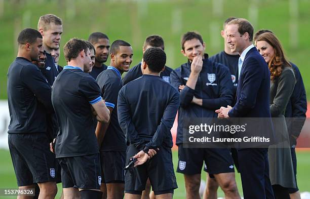 Prince William, Duke of Cambridge and Catherine, Duchess of Cambridge share a joke with the England team as they visit a training session at St...