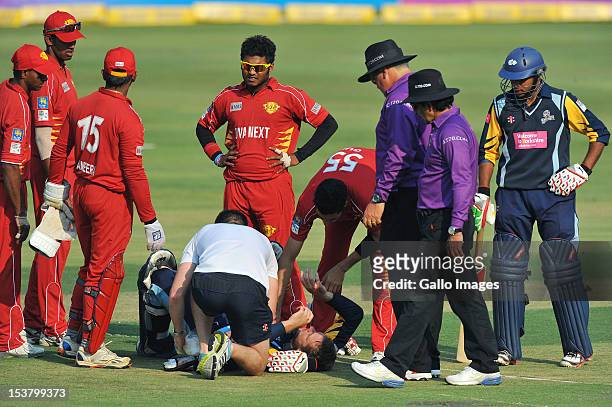 David Miller of Yorkshire receives medical attention after being struck by a bouncer from Umar Gul during the Karbonn Smart CLT20 pre-tournament...