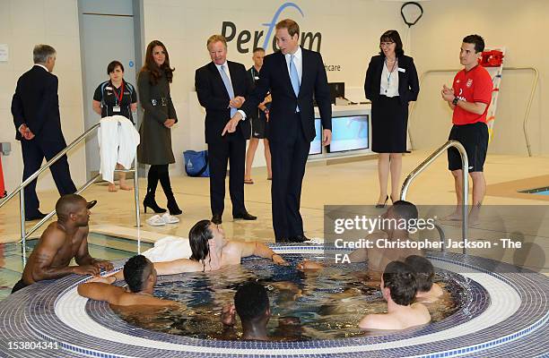 Prince William, Duke of Cambridge chats to Jermaine Defoe as Catherine, Duchess of Cambridge looks on in the hyrotherapy suite during the official...