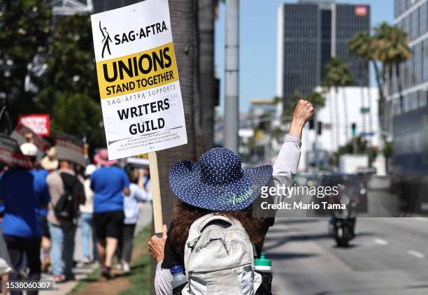 Sign reads 'Unions Stand Together' as SAG-AFTRA members walk the picket line in solidarity with striking WGA workers outside Netflix offices on July...