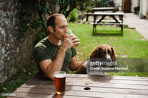 man  with dog in pub garden - 禿げ上がる ストックフォトと画像