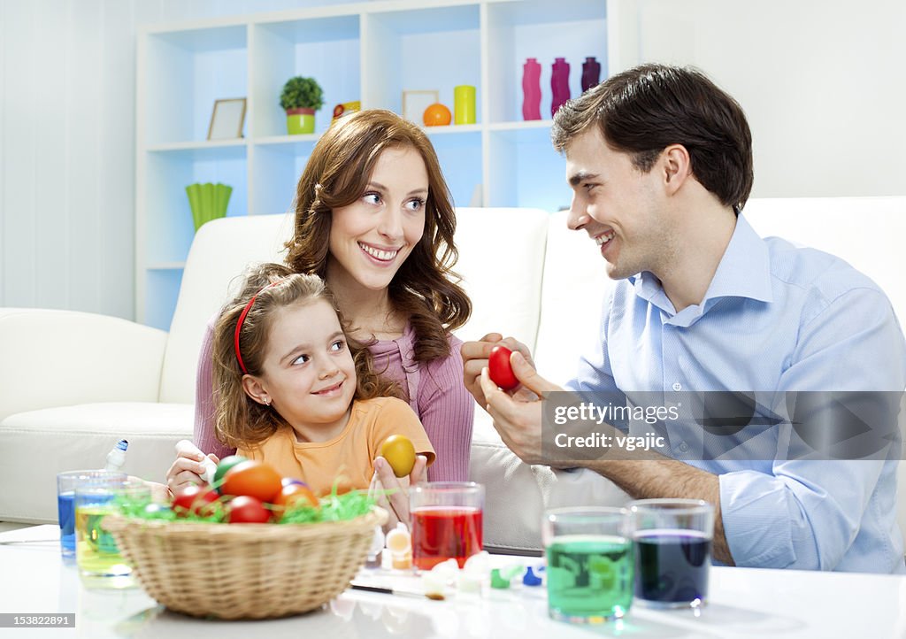 Familie malen Ostereier.