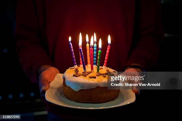 man, birthday cake, 8 glowing coloured candles - birthday cake stock pictures, royalty-free photos & images