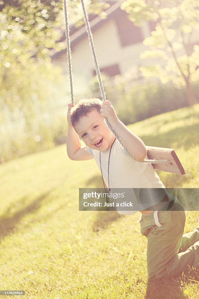 Portrait of smiling boy on swing.