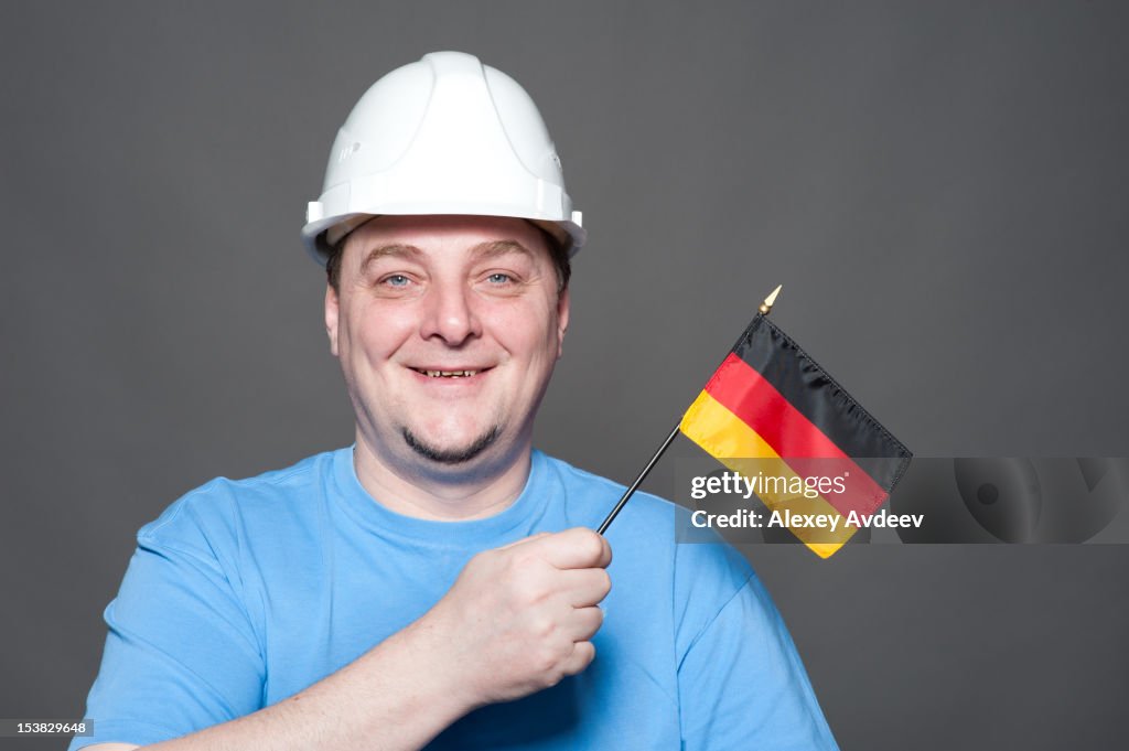 Homem vestindo Chapéu duro de construção tem uma Bandeira da Alemanha