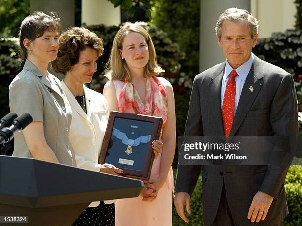 President George W. Bush gets emotional after giving Sandra Swanson the Medal of Freedom while her two daughters Brigid Swason Jones and Holly Walker...