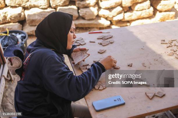 Palestinian archaeologist cleans some artefacts made of pottery back to the Roman era found inside a cemetery. The Palestinian Ministry of Tourism...