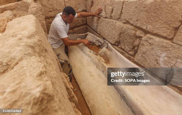 Palestinian archaeologist removes the sand from a lead sarcophagus at the cemetery. The Palestinian Ministry of Tourism and Antiquities in the Gaza...