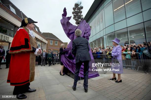 Britain's Queen Elizabeth II unveils a Diamond Jubilee monument to mark her 60 years on the throne, watched by the local mayor Colin Rayner, on...