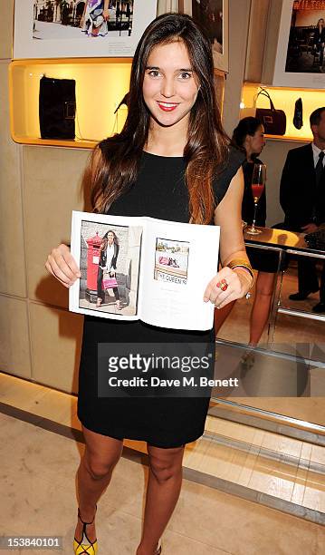 Model Viola Arrivabene Valenti Gonzaga poses with her photograph at the Roger Vivier Prismick A/W 2012 Exhibition at the Roger Vivier Flagship...