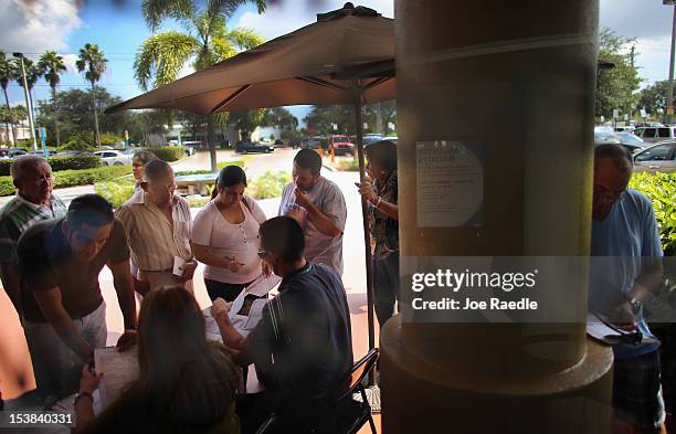 People deliver their voter registration forms to Miami-Dade Elections Department officials on the final day for voters to register to vote in the...