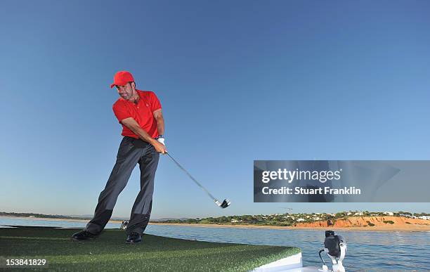 Ryder Cup captain Jose Maria Olazabal of Spain plays a shot from a boat to a target on a small boat prior to the start of the Portugal Masters golf...