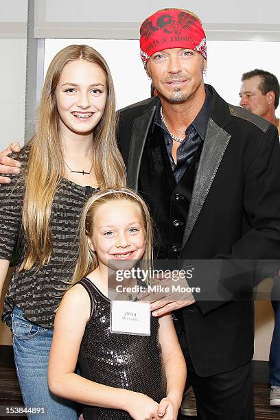 Musician Bret Michaels poses with daughters Raine Sychak and Jorja Sychak during the ribbon cutting ceremony for the new Bret Michael's Hospitality...