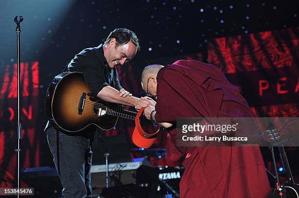Dave Matthews and His Holiness the Dalai Lama shake hands onstage at the One World Concert at Syracuse University on October 9, 2012 in Syracuse, New...