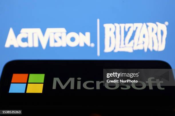 Microsoft logo displayed on a phone screen and Activision Blizzard logo displayed on a screen in the background are seen in this illustration photo...