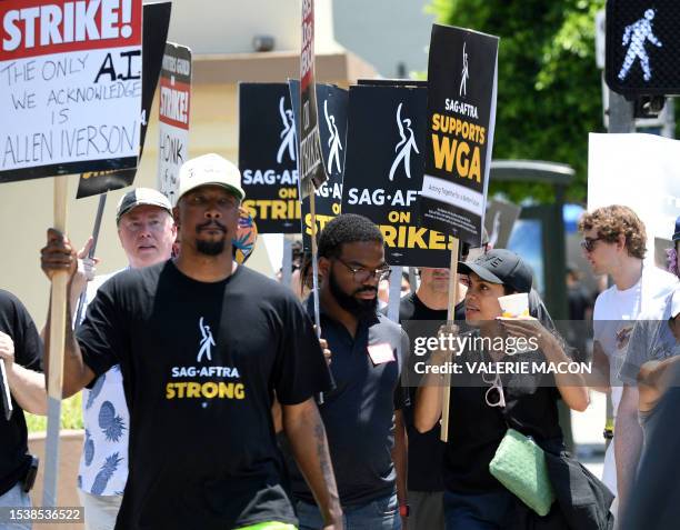 Actress Rosario Dawson walks with members of the Writers Guild of America and the Screen Actors Guild on a picket line outside of Paramount Studios...