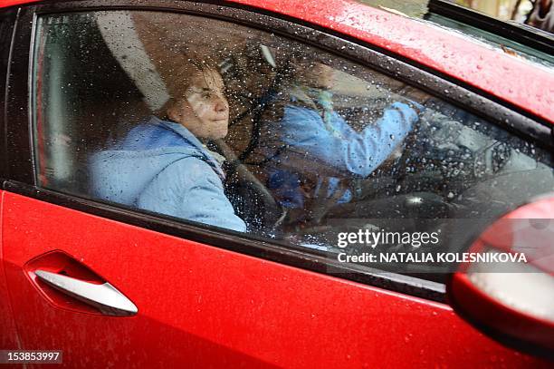 One of the members of the all-girl punk band "Pussy Riot," Yekaterina Samutsevich , sits in a car outside a court in Moscow, on October 10 shortly...