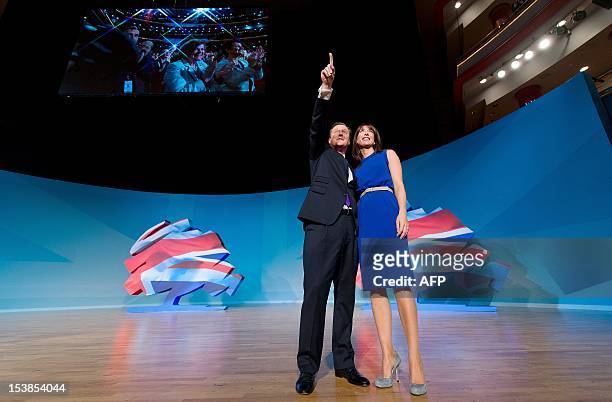 British Prime Minister David Cameron poses with his wife Samantha onstage after making his keynote address on the fourth day of the annual...