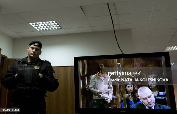 One of the jailed members of the all-girl punk band "Pussy Riot," Yekaterina Samutsevich, is seen on a seen as she speaks from a glass-walled cage in...