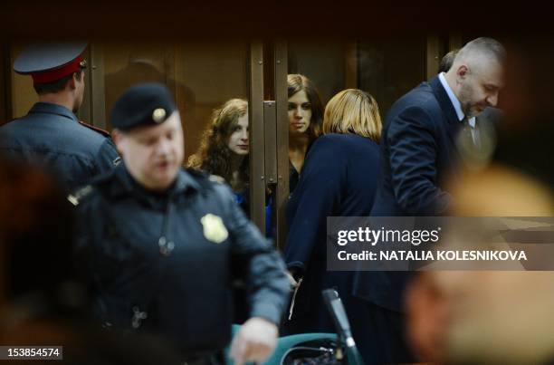 Two of the jailed members of the all-girl punk band "Pussy Riot," Maria Alyokhina and Nadezhda Tolokonnikova speak with a lawer from a glass-walled...