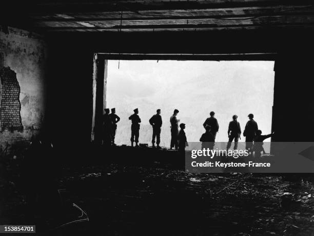 American troops looking through the huge window of the Berghof, Adolf Hitler's ruined mountain house, aka 'The Eagle's Nest in the Bavarian Alps on...