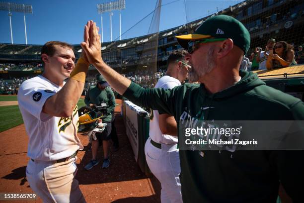 Bleday of the Oakland Athletics is congratulated at the dugout by Manager Mark Kotsay after the game against the Chicago White Sox at RingCentral...