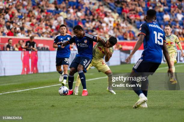 Alvas Powell of FC Cincinnati and Omir Fernandez of the New York Red Bulls battle for the ball during the first half at Red Bull Arena on July 12,...