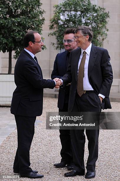 French President Francois Hollande welcomes U2 Frontman Bono, and Microsoft Corp. Chairman Bill Gates at the Elysee Palace on October 10, 2012 in...