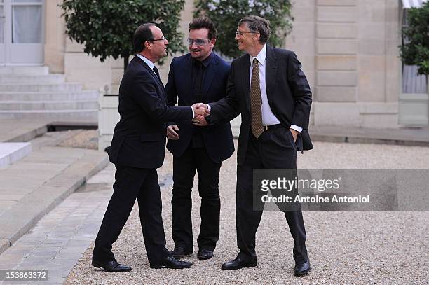 French President Francois Hollande welcomes U2 Frontman Bono, and Microsoft Corp. Chairman Bill Gates at the Elysee Palace on October 10, 2012 in...